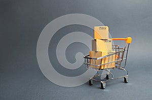 A pile of cardboard boxes in a supermarket trolley. concept of shopping in the online store . E-commerce, sales and sale of goods
