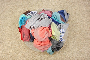 Pile of carelessly scattered clothes on floor. photo