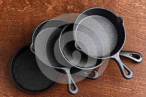 Pile of cast iron skillets on wood table