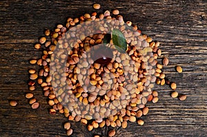 A pile of cherry stones and one cherry on an old wooden board