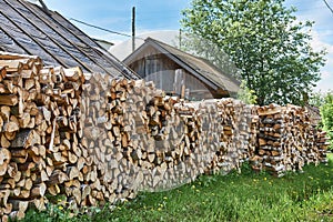 Pile of chopped birch firewood for the furnace in village