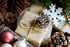 Pile of Christmas and New Year Gift Boxes Wrapped in Craft Paper Colorful Balls Big and Small Pine Cones Green Fir Tree Branches