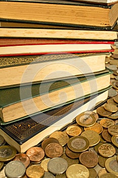 Pile of classics books surrounded with coins. The currency of the money is Brazilian Real