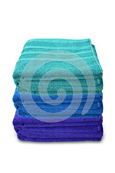 Pile of clean terry bath colored towels isolated on a white background, close-up, copy space, concept of cleanliness, bath