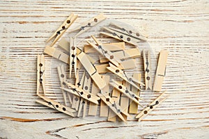 Pile of clothes pins on white wooden table, flat lay