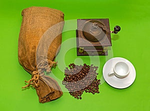 Pile of coffee beans with burlap sack and grinder