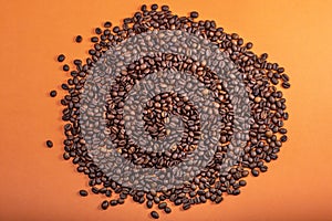 Pile of coffee beans on orange background. International Coffee Day concept. October 1st