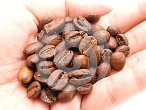 A pile of coffee beans in the palm of the hand.