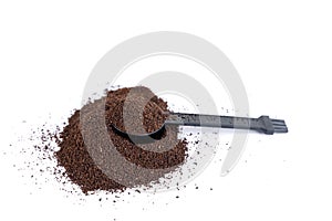 Pile of coffee grounds under a black scoop and brush