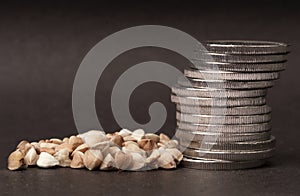 Pile of coins and buckwheat grains on a dark background
