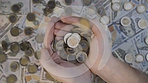 Pile of coins fall into hands