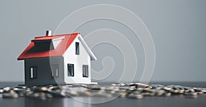Pile of coins with model house on wooden table, home loan, Save money concept, Property investment, house loan, reverse mortgage,