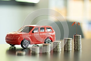 Pile of coins and red car personal finance planning concept background successful