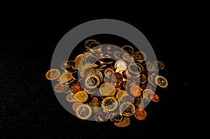 A pile of coins with a shiny gold coin in the middle
