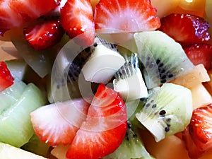 Pile of colored fruit and berries pieces, fruit salad