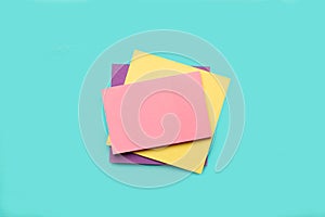 A pile of colored paper notes on a light blue background
