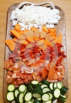 Pile of colored vegetables on wooden tray