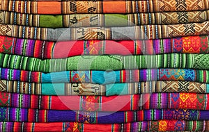 A pile of colorful Andean textiles photographed in the local handicraft market of Cusco