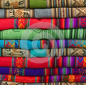 A pile of colorful Andean textiles photographed in the local handicraft market of Cusco