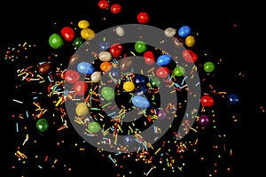 Pile of colorful candy drops on black background