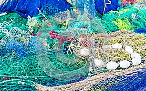 Pile of colorful commercial fishing nets at harbor