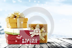 Pile of colorful gift box with ribbon and Boxing Day Sale text on wooden floor