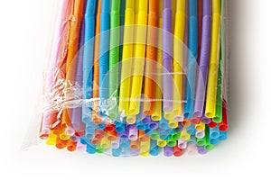 Pile of colorful plastic drinking straws in plastic wrapping. Close up