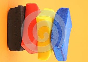 Pile of colorful plasticine blocks on orange background