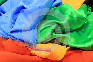 Pile of colorful silk fabrics. Mix of vibrant colors as background