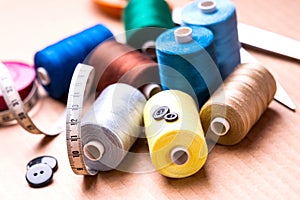 Pile of colorful spools of thread, buttons and measuring meter