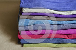 A pile of colorful T-shirts on a store counter