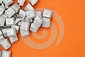 Pile of computer keyboard keys on the orange background
