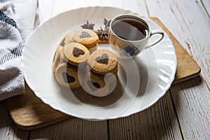 Pile of cookies along with a cup of coffee in a white plate