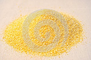 Pile of corn grits on coarse cloth close-up
