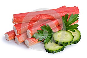 Pile of crab sticks, slices of cucumber and parsley leaf isolated on white