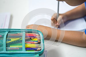 A pile of crayons on a student`s drawing table