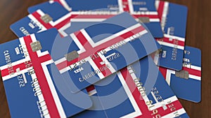 Pile of credit cards with flag of Iceland. Icelandic banking system conceptual 3D animation