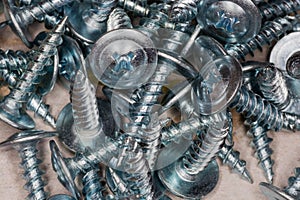 Pile of cross recessed sheetmetal screws, zinc plated, close-up photo