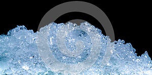 Pile of crushed ice cubes on dark background with copy space. Crushed ice cubes foreground for beverages