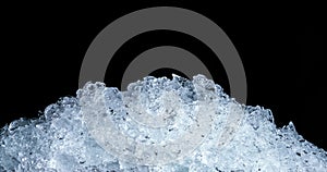 Pile of crushed ice cubes on dark background with copy space. Crushed ice cubes foreground for beverages