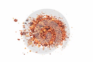 Pile crushed red cayenne pepper, dried chili flakes and seeds isolated on bright background.