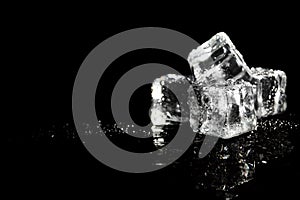 Pile of crystal clear ice cubes on black background.