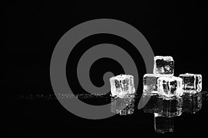Pile of crystal clear ice cubes on black. Space for text