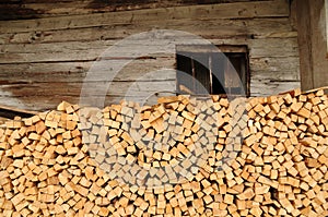 Pile of cutted woods accommodated in front of a hut