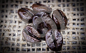 A pile of dark roast coffee beans, a blend of Arabica and Robusta.