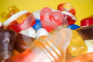 Pile of delicious colorful chewing candies background. Colourful sweets on yellow background