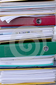 Pile of different file folders or ring binders full with office documents