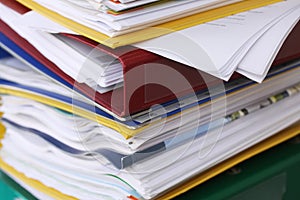 Pile of different file folders or ring binders full with office documents and paper work