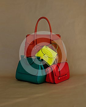 Pile of different leather trendy luxury coloured leather handbags