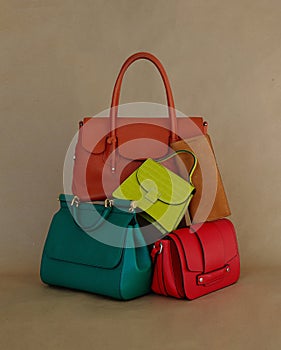 Pile of different trendy luxury coloured leather handbags. art. advertising